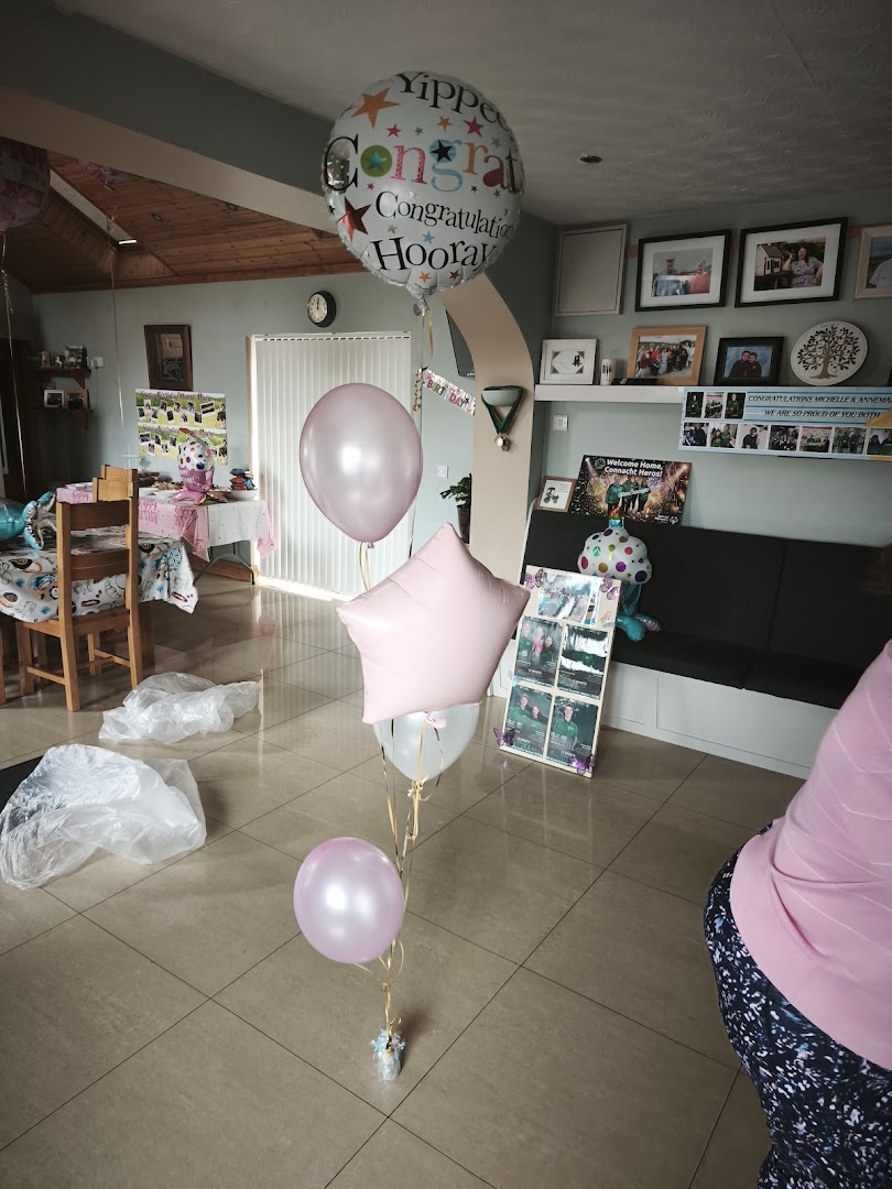 A bouquet of pink and white balloons with a congratulatory message.