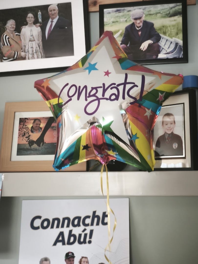 A star-shaped 'congrats!' balloon hanging in front of framed family photos.