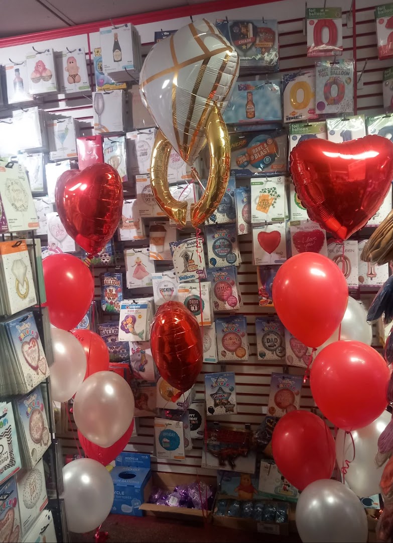 A display of red, white, and gold foil balloons inside a shop.
